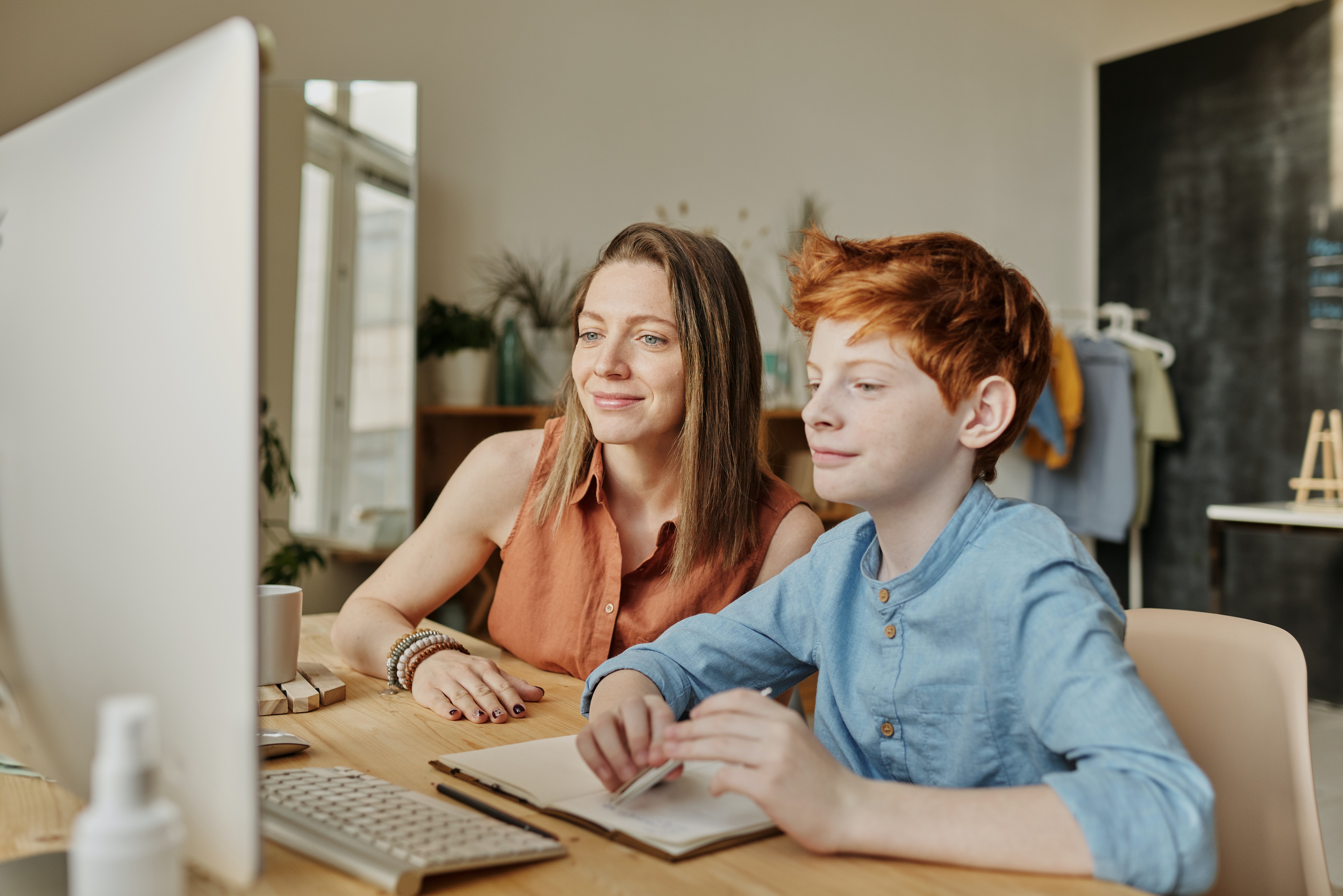 photo-of-woman-and-boy-smiling-while-watching-through-imac-4145350